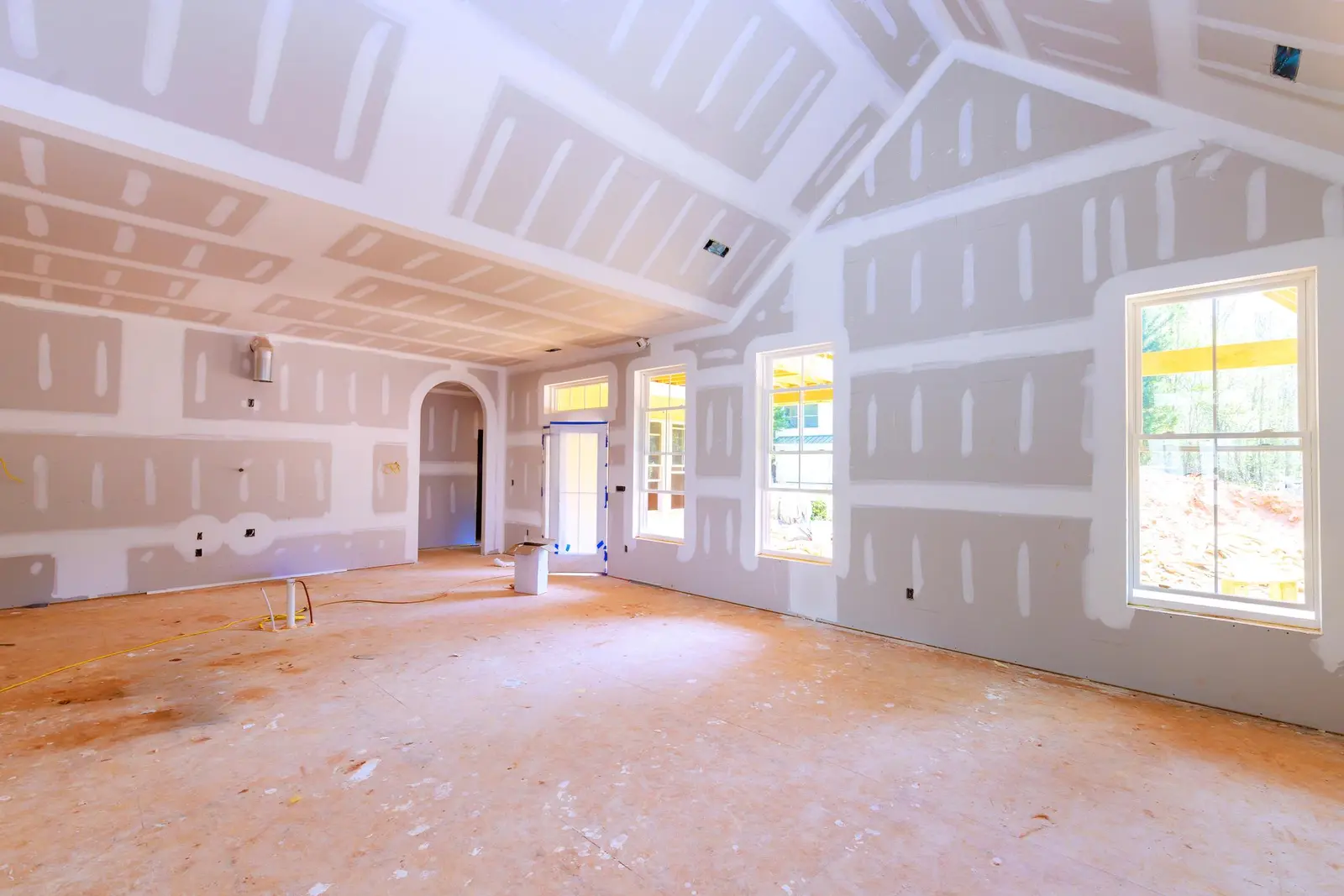 Drywall taped and mudded in a large room before painting